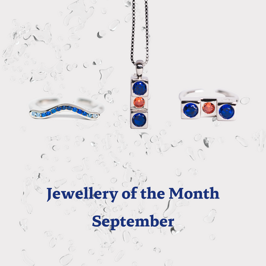 Jewellery of the Month for September featuring a trio of silver jewellery pieces: a wavy ring adorned with blue zircon, a pendant with blue and orange zircon stones, and a matching ring. The jewellery highlights the September birthstone with its rich blue hues.